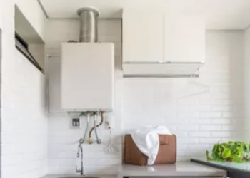 Ele está lá o ano todo, mas com a proximidade do inverno, aumenta a procura de novos aquecedores de água quando o existente não está funcionando devidamente. Instalado nessa área de serviço executada pelo arquiteto Bruno Moraes, o equipamento está pronto para prover água quente para duchas e torneiras | Projeto BMA Studio | Foto: Guilherme Pucci