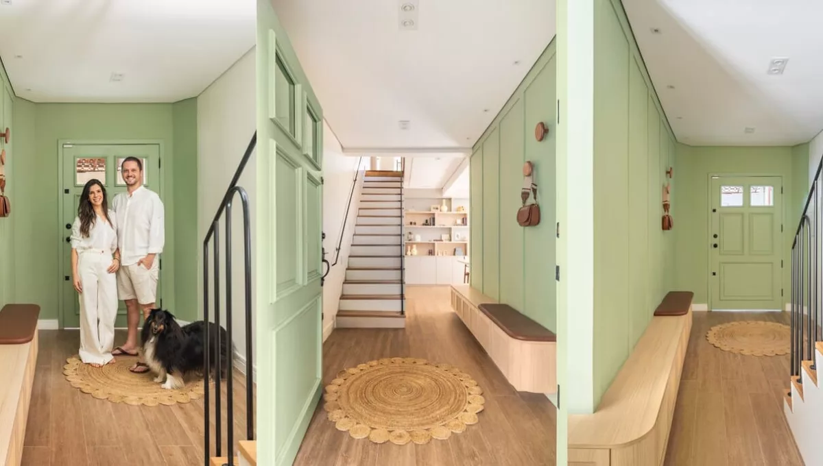 No sobrado onde residem a Carol e Francesco, o arquiteto Bruno Moraes escolheu o aconchego do verde que coloriu a marcenaria verde (essa mesma estrutura, do lado da sala de estar, recebeu a TV) e a porta. Para fechar a composição, a naturalidade da madeira presente no piso, no banco, e na dupla de penduradores |Projeto BMA Studio | Fotos: Guilherme Pucci