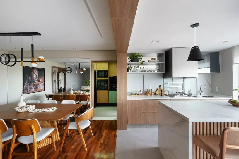 Reforma de apartamento explora dimensões generosas da varanda e agrega soluções como a inserção de um passa-prato na cozinha