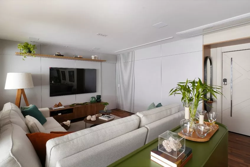 Reforma de apartamento explora dimensões generosas da varanda e agrega soluções como a inserção de um passa-prato na cozinha