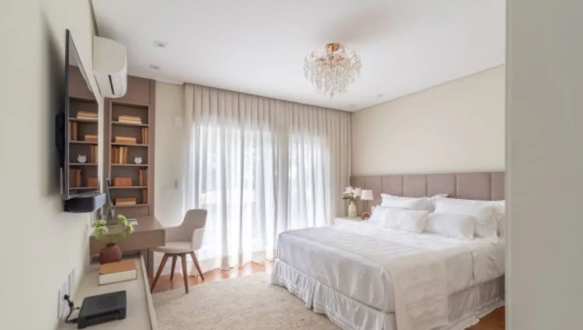 Neste projeto assinado pela arquiteta Isabella Nalon, a composição da cama se destaca e dita o tom acolhedor do espaço, com base clara, tecidos texturizados e arranjo equilibrado de travesseiros que valorizam  o conforto e a estética | Fotos: Julia Herman