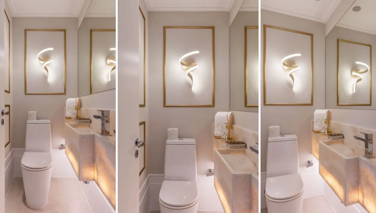 Neste lavabo, a arquiteta Cristiane Schiavoni uniu tons claros e materiais nobres, caso da bancada nesta 
pedra translúcida, que teve sua base iluminada. Entregando o clássico, a boiserie dourada enquadra a luminária tal qual uma obra de arte | Fotos: Rafael Renzo