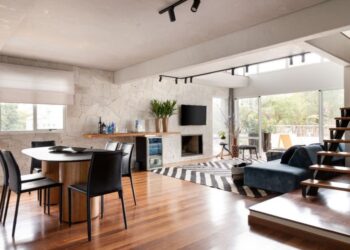 O apartamento com abundante luz natural ganhou uma parede revestida com granito rústico combinada com o aconchego do piso de madeira | Projeto: Daniela Funari Arquitetura | FOTO: Julia Novoa Fotografia