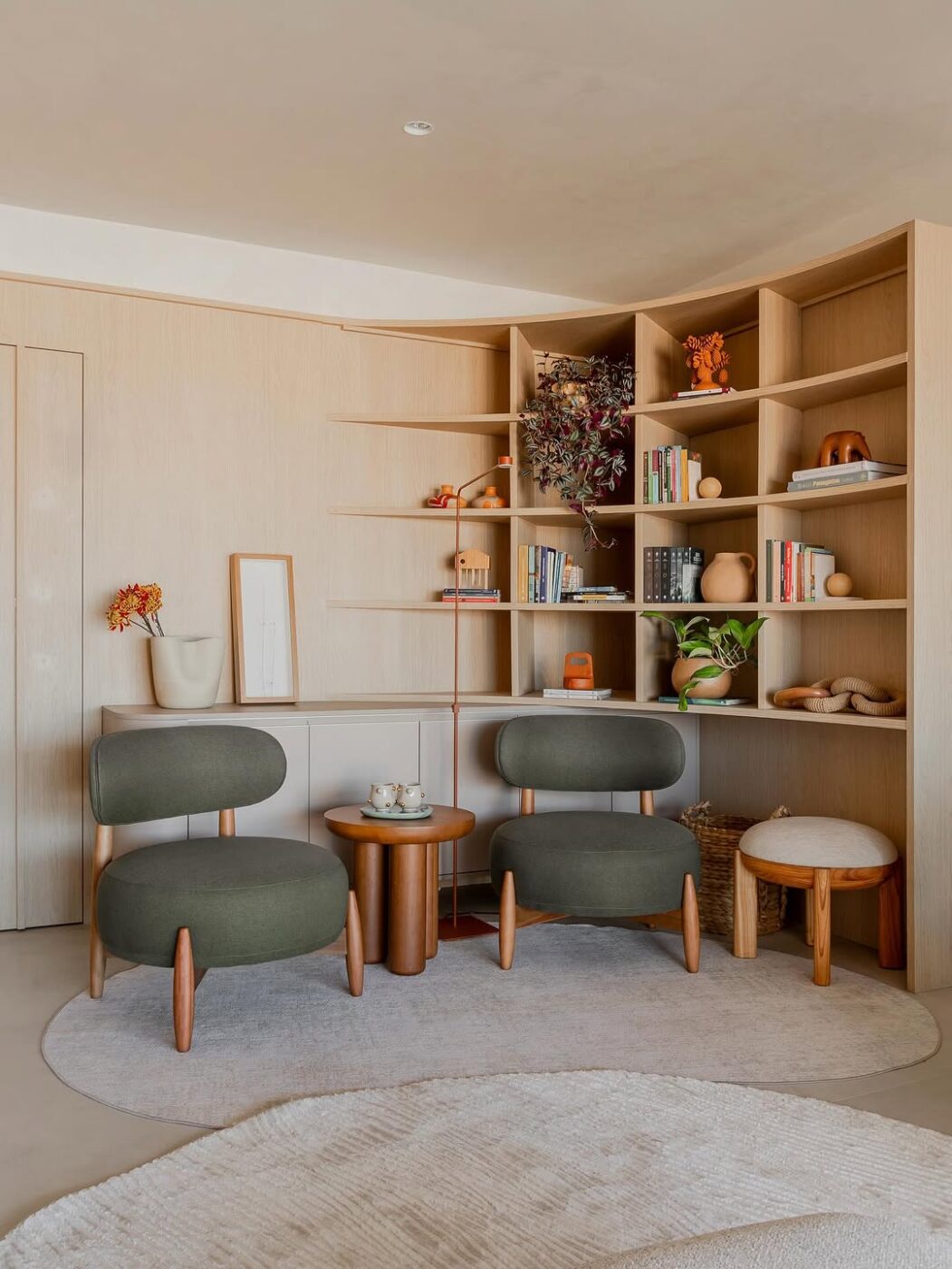 Leito de leitura ao lado de estante rústica de madeira com livros e cestos decorativos em ambiente natural.