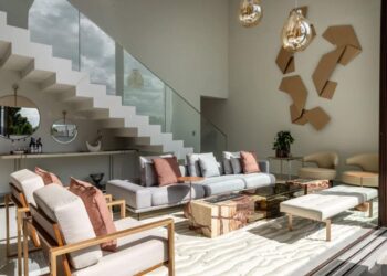 O famoso vão da escada deve ser deixado de lado? A resposta é não: neste projeto do Meneghisso & Pasquotto Arquitetura, os arquitetos planejaram o espaço com espelho, mobiliário e virou um apoio de bar em casa | Foto: JP Image