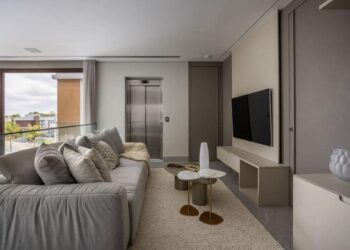 Nessa residência, o espaço de circulação acessa os dormitórios da família e foi projetado para ser uma sala íntima da família. Assim, os profissionais do escritório Meneghisso & Pasquotto Arquitetura definiram um sofá aconchegante para os momentos antes da hora de dormir | Foto: JP Image