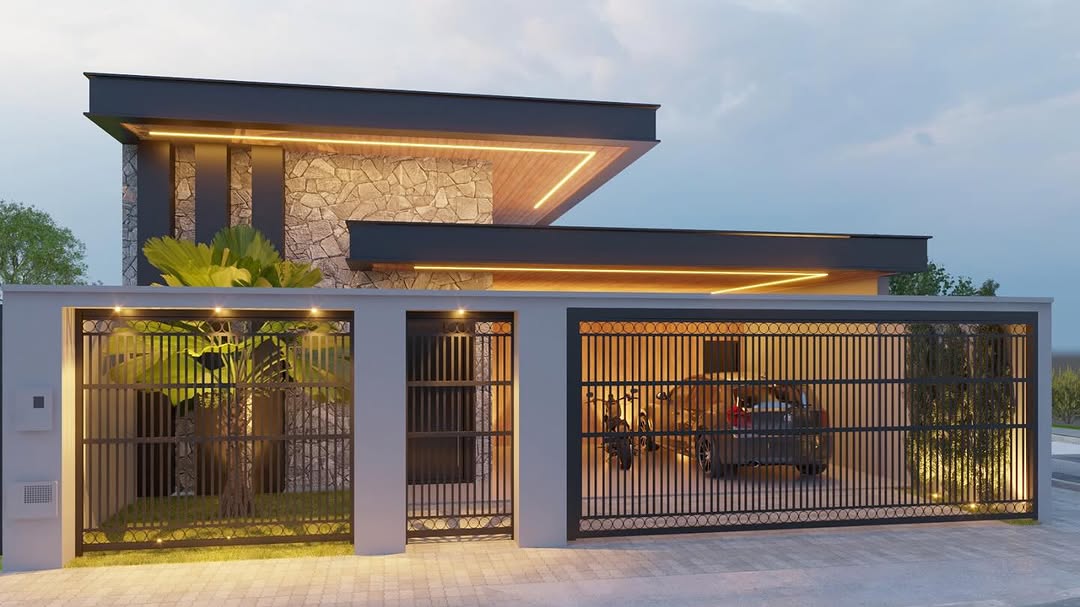 Fachada de casa moderna com aplicação de pedra moledo, iluminação embutida e garagem com portão de grade metálica.