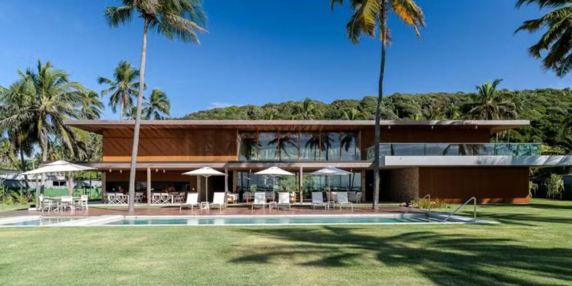 Sala de estar com pé-direito duplo e vista para o mar de Alagoas, arquitetura de Isabela Bicalho