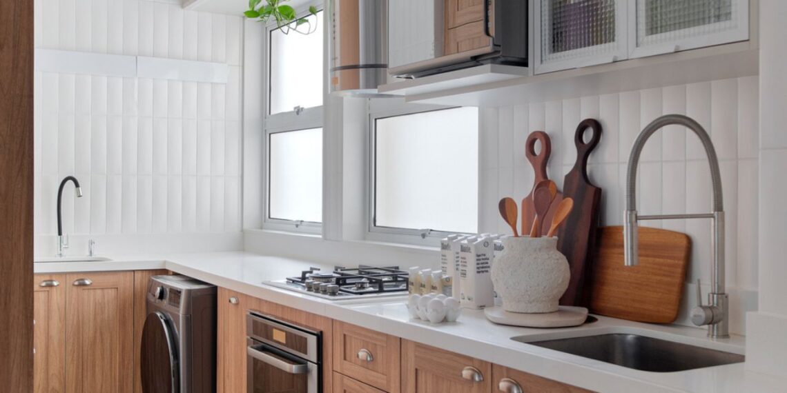 A cozinha combina funcionalidade e estilo com marcenaria em madeira natural, piso clássico de pastilhas e luz suave. Detalhes artesanais e plantas trazem vida ao espaço, criando uma mistura perfeita entre praticidade contemporânea e charme retrô. | Foto: Raiana Medina