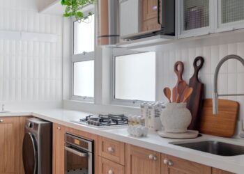 A cozinha combina funcionalidade e estilo com marcenaria em madeira natural, piso clássico de pastilhas e luz suave. Detalhes artesanais e plantas trazem vida ao espaço, criando uma mistura perfeita entre praticidade contemporânea e charme retrô. | Foto: Raiana Medina