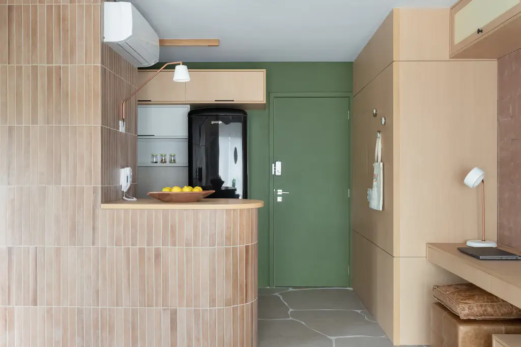 Estúdio de 40 m² aposta em tons terrosos, porcelanato orgânico e muxarabi para integrar lavanderia, cozinha e estar com leveza e funcionalidade.