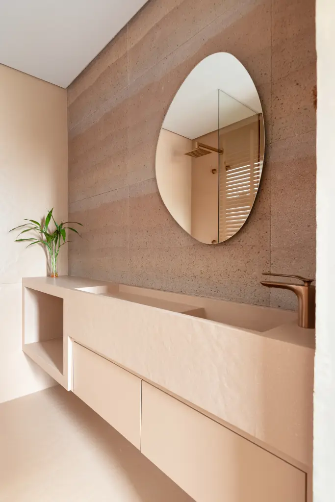 Estúdio de 40 m² aposta em tons terrosos, porcelanato orgânico e muxarabi para integrar lavanderia, cozinha e estar com leveza e funcionalidade.