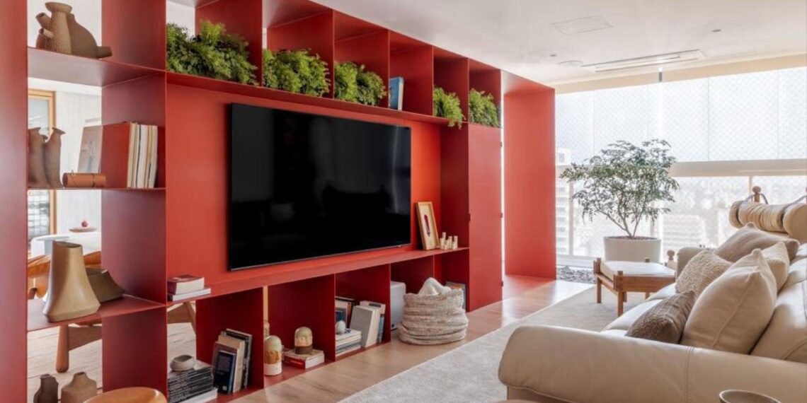 Esta estante de serralheria planejada pelo arquiteto Raphael Wittmann foi executada com chapa de 5mm soldada e pintada no próprio local. O tom bordô chama atenção e aquece o espaço | Projeto Rawi Arquitetura + Design | Foto: Rafael Renzo