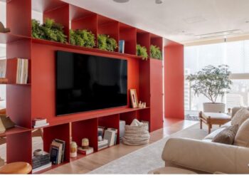 Esta estante de serralheria planejada pelo arquiteto Raphael Wittmann foi executada com chapa de 5mm soldada e pintada no próprio local. O tom bordô chama atenção e aquece o espaço | Projeto Rawi Arquitetura + Design | Foto: Rafael Renzo