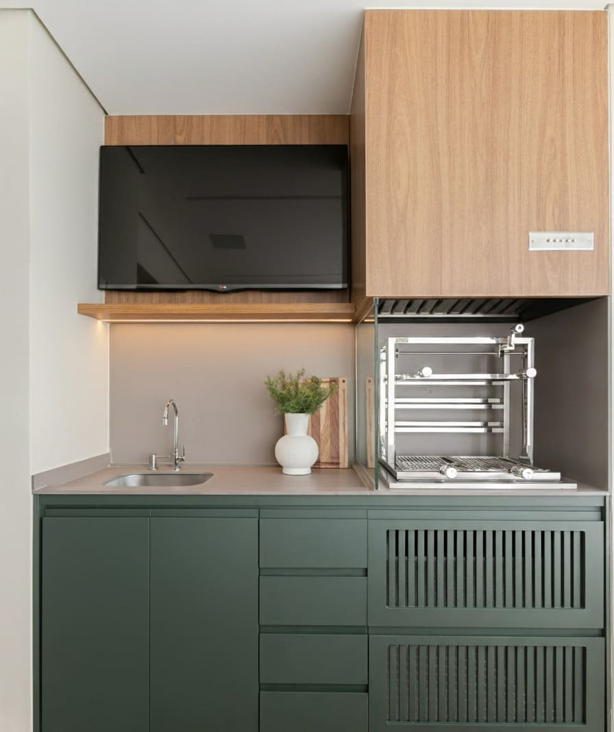 Cozinha planejada com armários verde-musgo e detalhes em madeira, exemplo de verde escuro na decoração contemporânea.