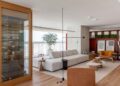 Batizado de ‘Apartamento Ripas’, o projeto do arquiteto Raphael Wittmann exibe uma área de estar grandiosa que reflete a identidade dos moradores. Uma adega entrega imponência logo na entrada e possui duas portas que servem ao estar e à sala de jantar | Projeto Rawi Arquitetura + Design | Foto: Rafael Renzo