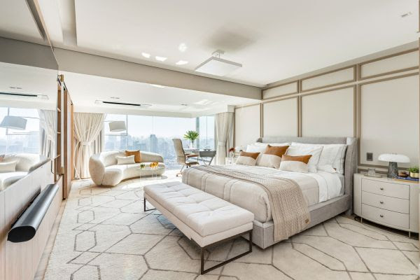 Sala íntima integrada ao dormitório valoriza conforto, leitura e momentos a dois