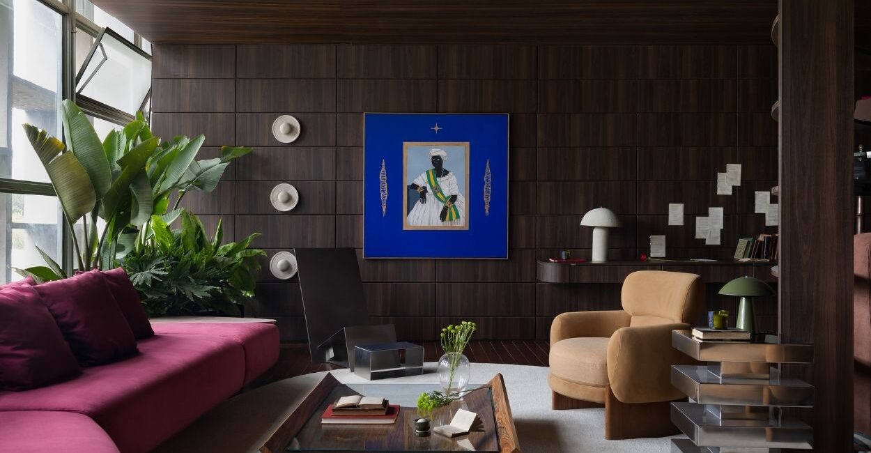 A paleta terrosa e profunda — com ocres, azuis e vermelhos — dialoga com origem, chão e realidade. Sofá e poltronas Breton, assinados pelo arquiteto. Mesa de centro, de Sergio Faher. Piso Ipê Stain, da Akafloor. Foto: Adriano Pacelli