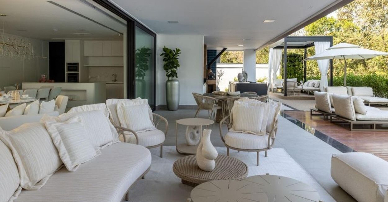 Nesta área externa, Alexandre Pasquotto e Mariana Meneghisso ornaram o espaço com sofá curvo e poltronas de diferentes texturas e de materiais de fácil manutenção | Projeto Meneghisso & Pasquotto Arquitetura | Foto: JP Image