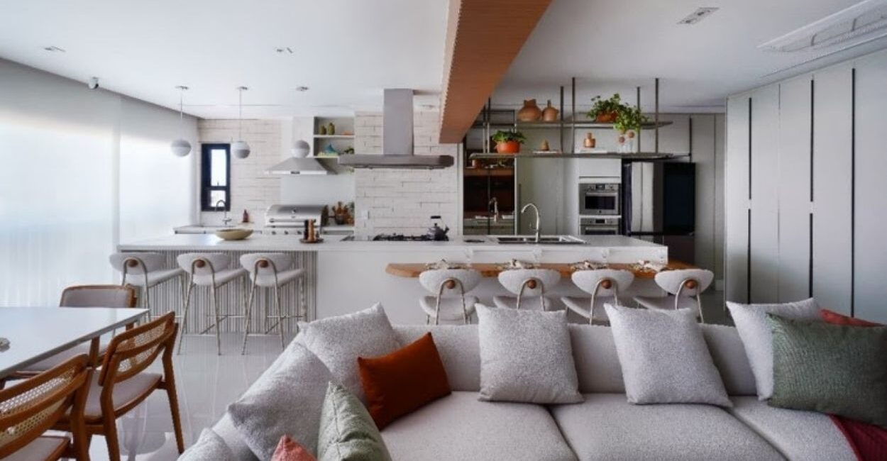 A conexão entre a cozinha e o gourmet pode ser executada de diversas maneiras, inclusive como protagonistas da área social do imóvel, assim como a arquiteta Rosangela Pena executou no projeto do apartamento acima. Nos dias de eventos, a cozinha é o apoio para complementar os pratos que acompanharão o churrasco | FOTO: Sidney Doll