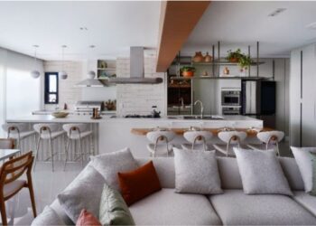 A conexão entre a cozinha e o gourmet pode ser executada de diversas maneiras, inclusive como protagonistas da área social do imóvel, assim como a arquiteta Rosangela Pena executou no projeto do apartamento acima. Nos dias de eventos, a cozinha é o apoio para complementar os pratos que acompanharão o churrasco | FOTO: Sidney Doll