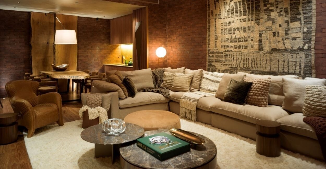 Do tijolo aparente à escolha das capas das almofadas, cada elemento deste ambiente produzido pela arquiteta Denise Barretto evoca uma tonalidade diferente dentro da paleta do marrom que torna o projeto mais aconchegante e requintado | Foto: Rômulo Fialdini
