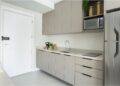 Em imóveis com metragem reduzida, como no caso dos studios, é possível garantir uma cozinha otimizada: nesse projeto do escritório ResiliArt Arquitetura, a marcenaria envolve o espaço da cozinha que começa desde a porta de entrada. É preciso definir o que é realmente necessário: o cooktop de duas bocas atende com eficácia e não houve a instalação do forno, haja vista não se fazia fundamental na rotina do morador | FOTO: Kelly Queiroz