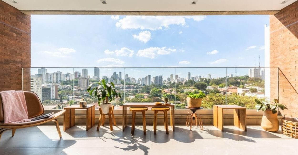 Ao invés de ambientes feitos apenas para impressionar, muitos moradores estão à procura do acolhimento à sua maneira. Na varanda deste apartamento, o arquiteto Bruno Moraes posicionou bancos e mesas produzidos a partir da madeira reaproveitada da escada do apartamento, dando uma nova vida a um material que antes seria descartado | Projeto BMA Studio | Foto: Guilherme Pucci