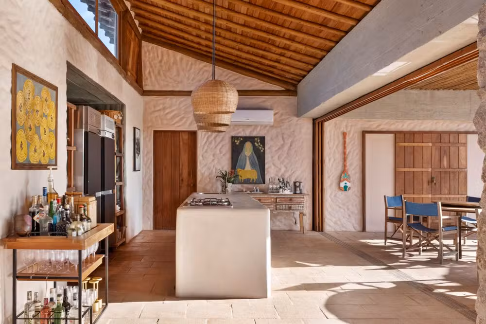 Casa Berimbau, na Bahia, se fecha para a rua e se abre para uma piscina que parece estar dentro e fora da sala ao mesmo tempo