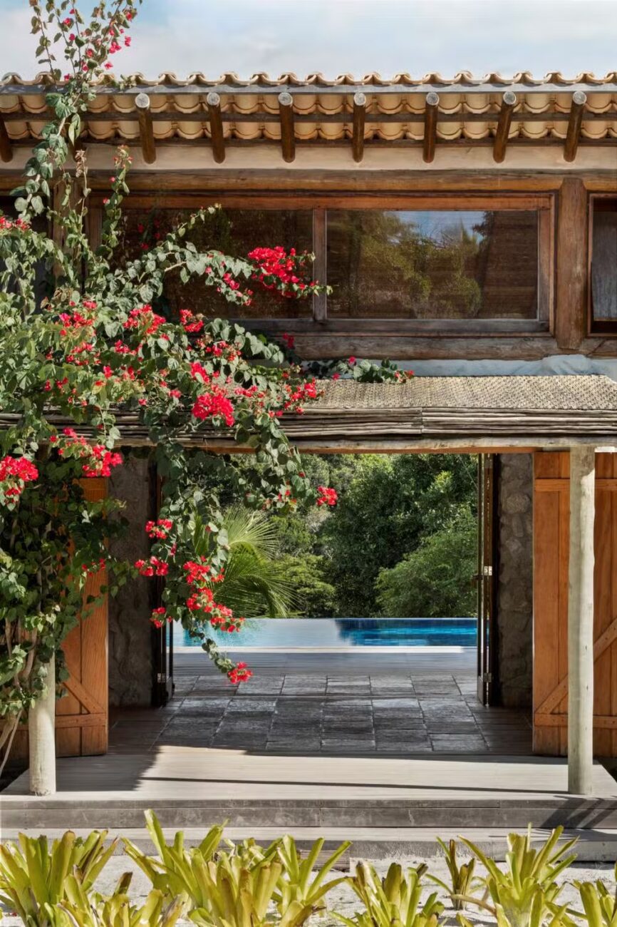 Casa Berimbau, na Bahia, se fecha para a rua e se abre para uma piscina que parece estar dentro e fora da sala ao mesmo tempo