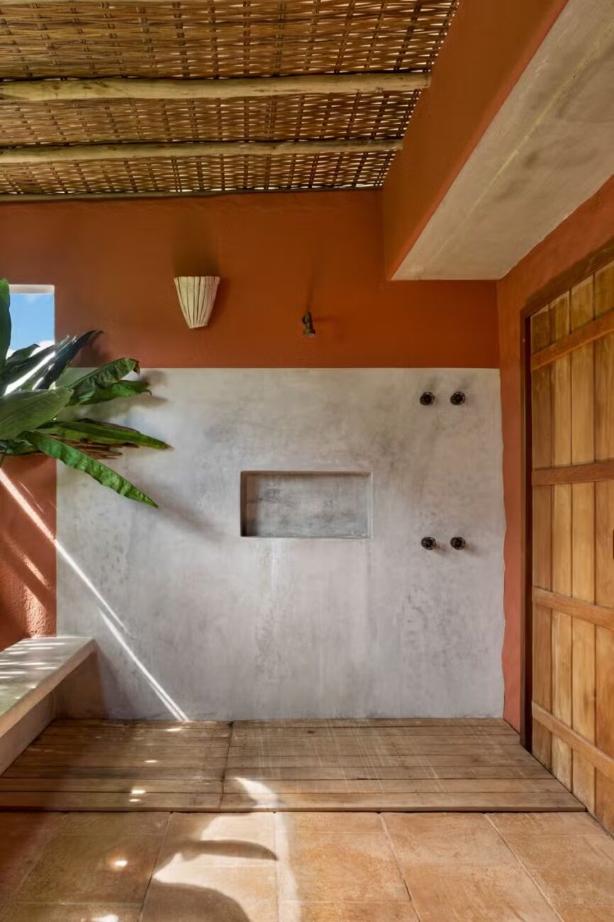 Casa Berimbau, na Bahia, se fecha para a rua e se abre para uma piscina que parece estar dentro e fora da sala ao mesmo tempo