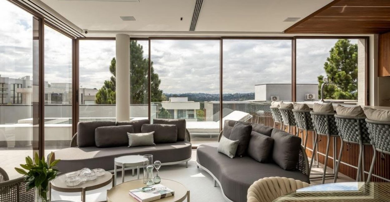 Nesta residência na Granja Viana, as esquadrias escolhidas pelos arquitetos Alexandre Pasquotto e Mariana Meneghisso proporcionam iluminação e ventilação natural para a área gourmet e o vidro tratado impede que o sol desgaste os móveis internos | Projeto Meneghisso & Pasquotto Arquitetura | Foto: JP Image
