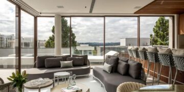 Nesta residência na Granja Viana, as esquadrias escolhidas pelos arquitetos Alexandre Pasquotto e Mariana Meneghisso proporcionam iluminação e ventilação natural para a área gourmet e o vidro tratado impede que o sol desgaste os móveis internos | Projeto Meneghisso & Pasquotto Arquitetura | Foto: JP Image