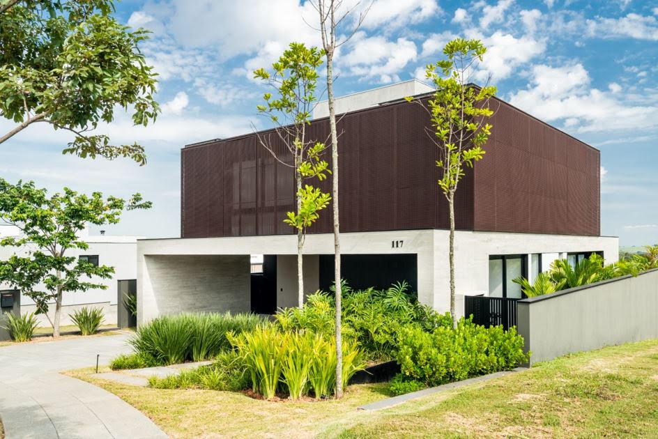 Paisagismo residencial recusa a piscina exposta e usa vegetação tropical para resolver o problema de privacidade que o terreno não deu de graça