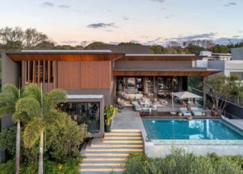 Com uma área de convivência conectada a espaços externos, o verde parece se fundir à arquitetura. O entorno da casa contém espécies como palmeira-rabo-de-raposa, jabuticabeira, imbê e pau-brasil | Paisagismo de Depieri Paisagismo, arquitetura de Denise Zuba Arquitetos, construção de Centra Engenharia e foto de Edgar Cesar