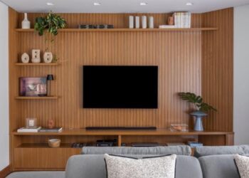 Neste projeto executado pelo arquiteto Paulo Tripoloni, a TV ganhou espaço na marcenaria com o painel sob medida | Foto: Rafael Renzo